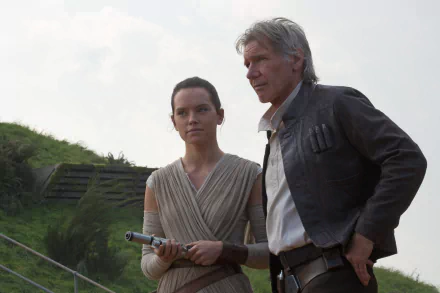 Harrison Ford as Han Solo and Daisy Ridley as Rey stand together in a scene from Star Wars Episode VII: The Force Awakens, set against a lush green backdrop.