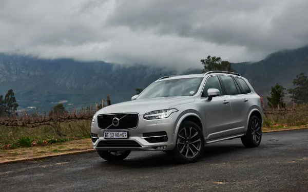 Silver Volvo XC90 SUV parked on a road with cloudy mountains in the background, captured in 4K Ultra HD as a PC desktop wallpaper and background.