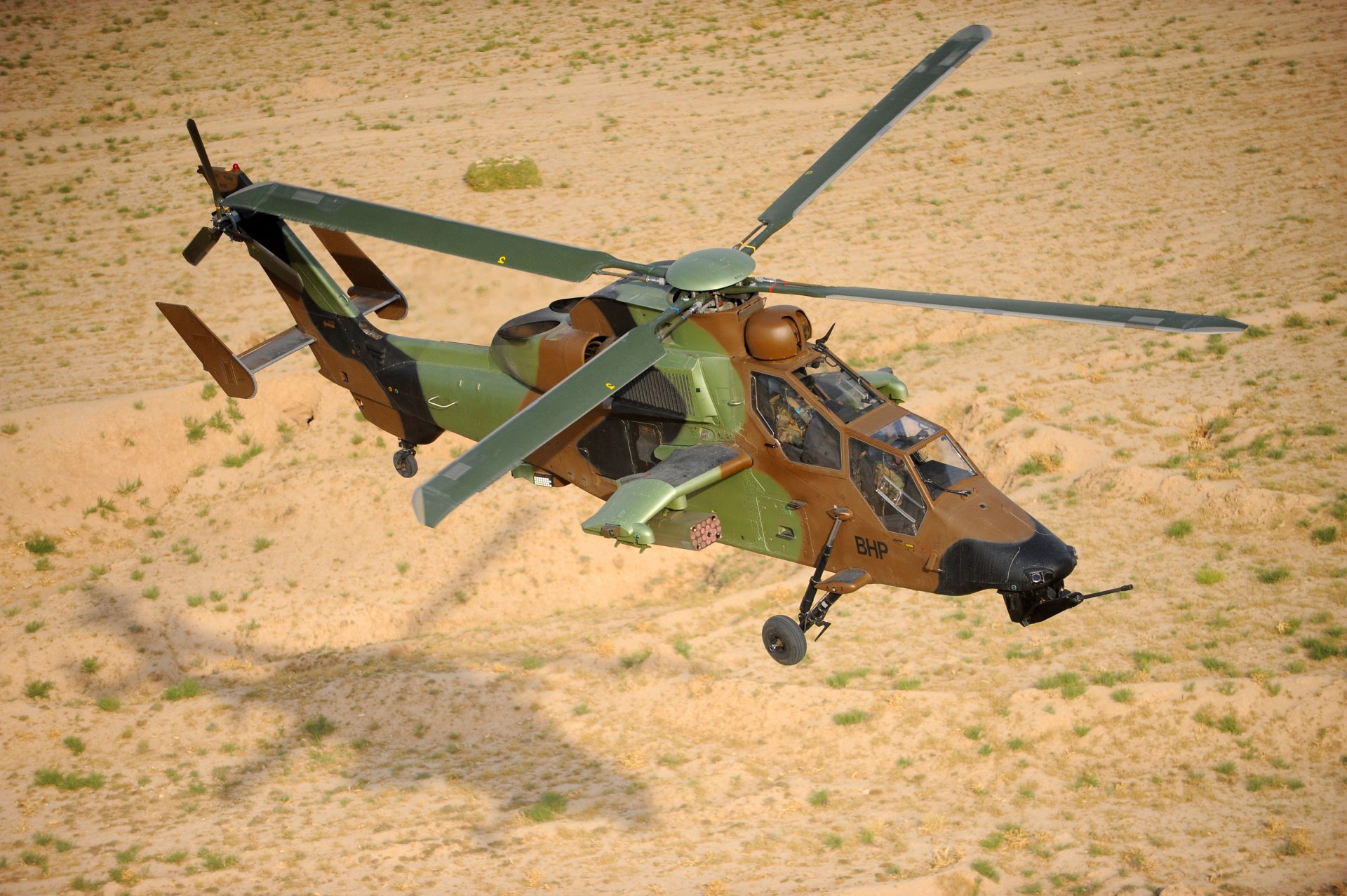 Eurocopter Tiger attack helicopter in military camouflage flying over desert — 4K Ultra HD PC desktop wallpaper/background.
