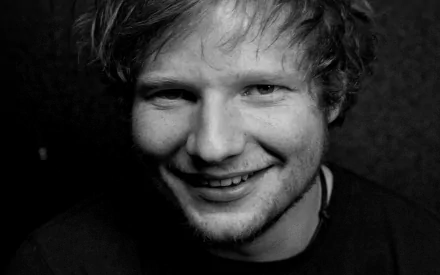 Black and white HD desktop wallpaper of English singer Ed Sheeran with a warm smile.