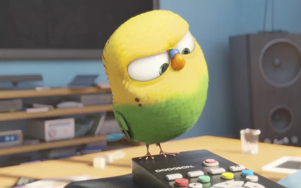 A colorful bird from The Secret Life of Pets stands atop a remote control, showcasing a playful expression in this HD desktop wallpaper.