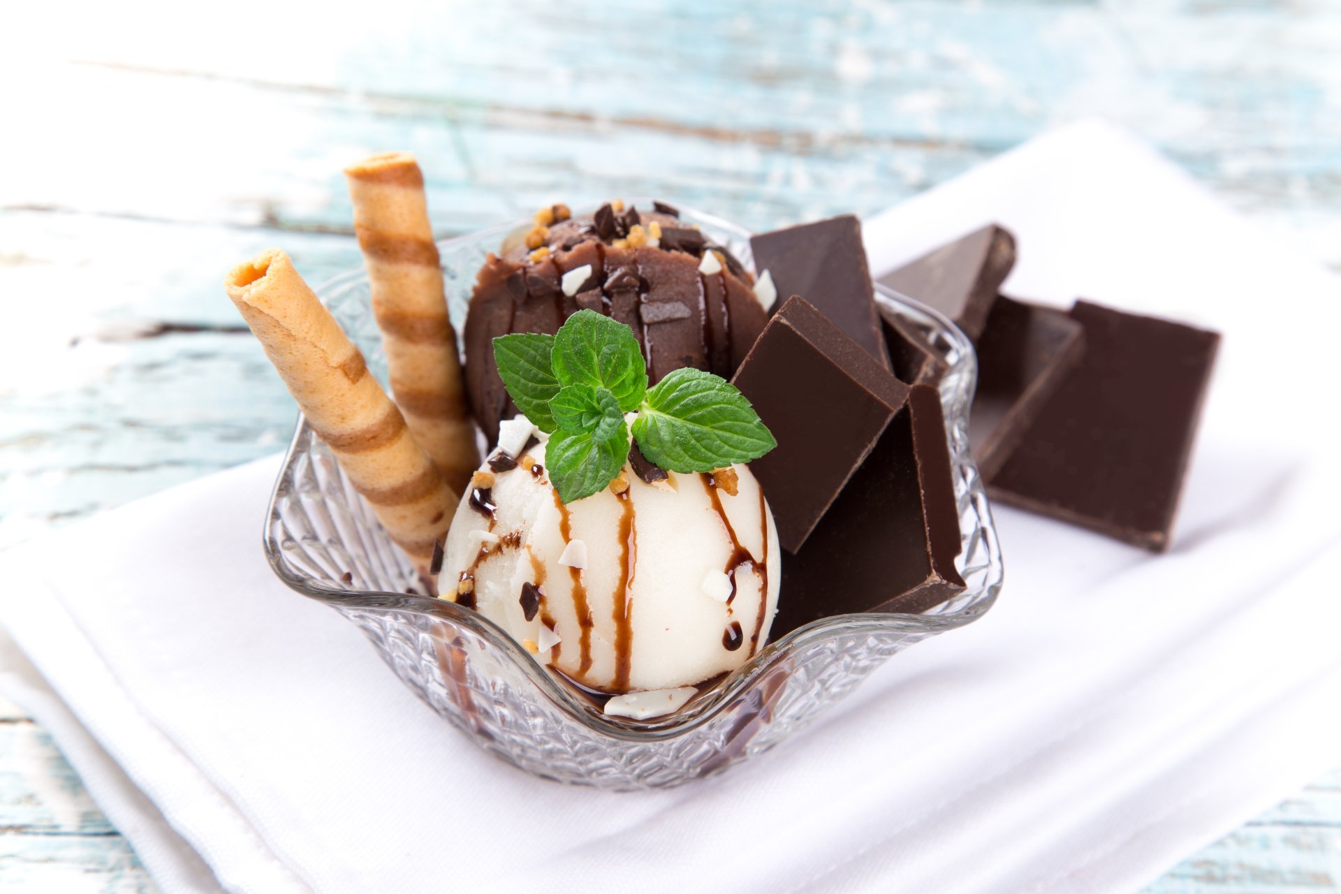 A 4K Ultra HD wallpaper featuring mint chocolate ice cream with chocolate wafers and chunks of chocolate on a rustic wooden table.