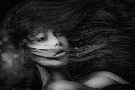 Black and white HD desktop wallpaper featuring a close-up of a woman’s face with flowing hair, creating a striking and artistic visual impact.