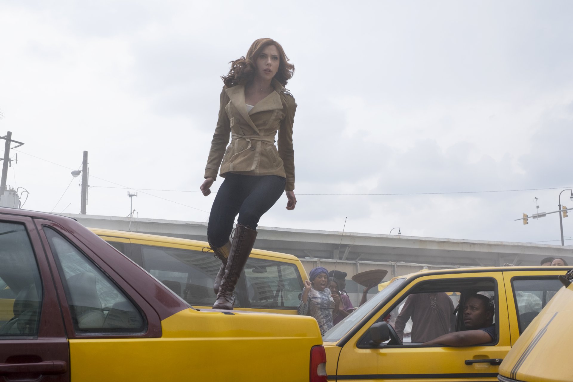 Natasha Romanoff, also known as Black Widow, portrayed by Scarlett Johansson, navigates a chaotic traffic scene in this dynamic HD wallpaper from *Captain America: Civil War*.