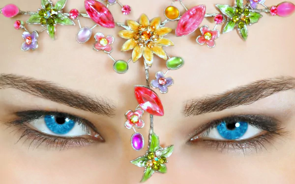 Close-up of a woman’s blue eyes adorned with a colorful jeweled bindi, captured in high definition for a striking PC desktop wallpaper background.