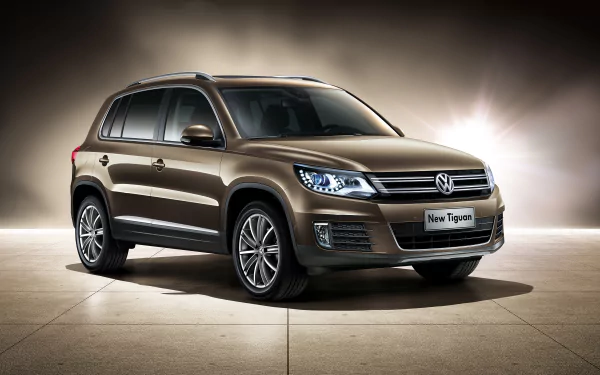HD PC desktop wallpaper featuring a brown Volkswagen Tiguan SUV, showcasing the vehicle's sleek design and modern headlights against a neutral background.