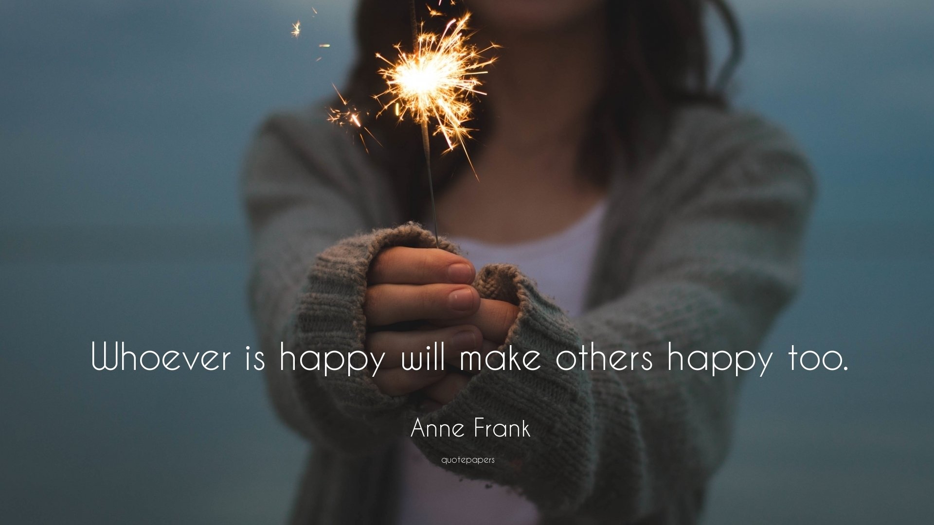 HD PC desktop wallpaper & background: blurred person holds a lit sparkler, white quote text reads Whoever is happy will make others happy too. — Anne Frank