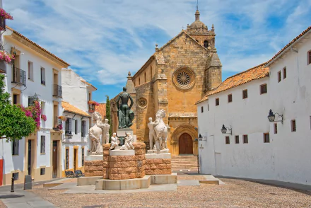HD desktop wallpaper of a Córdoba, Spain plaza with a historic church façade and a central man-made fountain statue framed by whitewashed buildings.