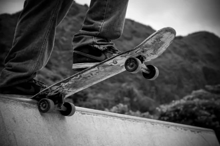 Black and white outdoor image of a skateboarder performing a trick on a ramp, captured in HD quality for a dynamic PC desktop wallpaper background.