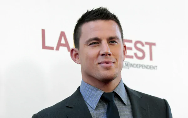 HD desktop wallpaper featuring American actor and celebrity Channing Tatum in a dark suit and tie, posing confidently against a light background.