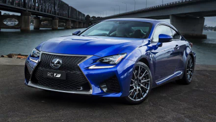 HD desktop wallpaper featuring a sleek blue Lexus RC sports car parked near an urban waterfront with bridges in the background.