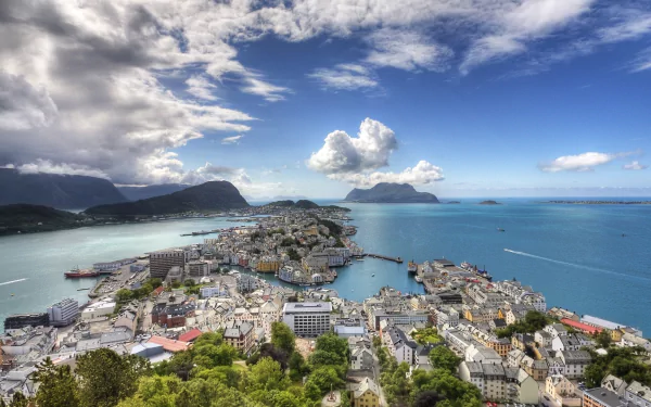A panoramic HD view of Ålesund cityscape along Norway’s coastline, showcasing the ocean, man-made structures, and mountainous backdrop under a vibrant sky.