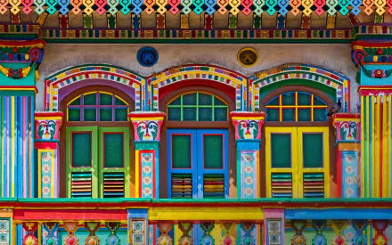 Vibrant colorful facade of a traditional Indian building with intricately painted arches and windows, captured in HD for a striking desktop wallpaper background.