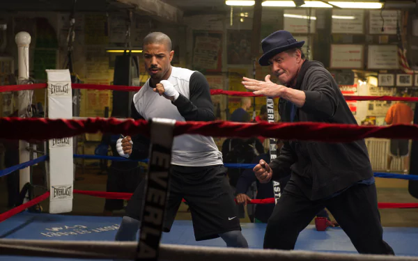 HD desktop wallpaper featuring Sylvester Stallone as Rocky Balboa training Michael B. Jordan as Adonis Creed in the boxing ring from the movie Creed.