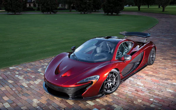 Red McLaren P1 supercar parked on a brick driveway, high-detail shot for 4K Ultra HD PC desktop wallpaper and background.