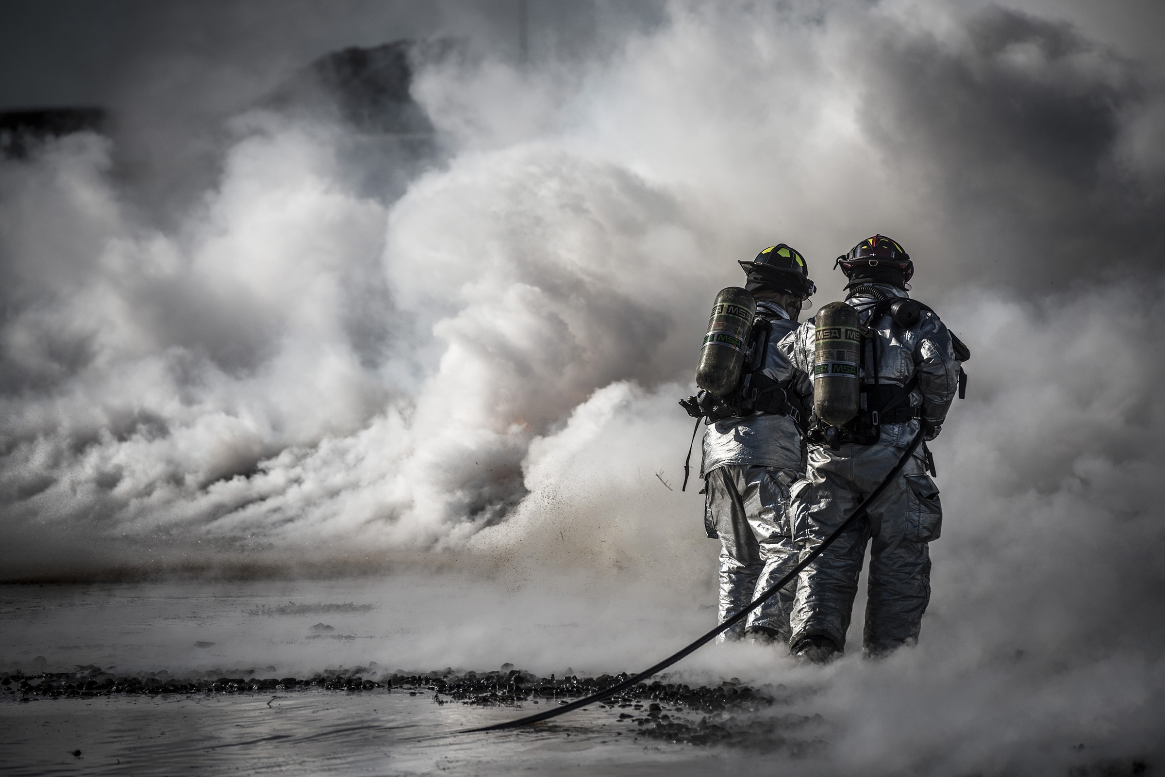 Firemen training in protective suits by skeeze