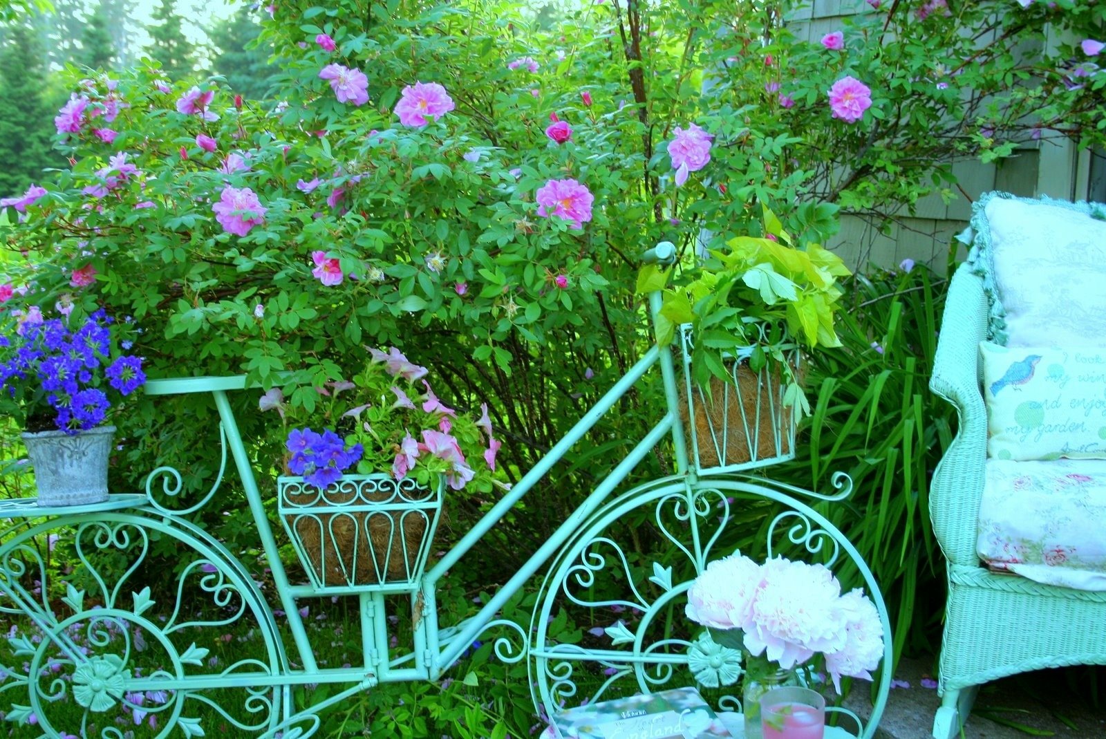 A vibrant garden scene featuring a pastel bicycle adorned with flowers, alongside a decorative chair, encapsulating the colors and beauty of spring.