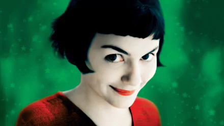 HD desktop wallpaper featuring Audrey Tautou as Amelie with a playful smile and green starry background from the movie Amelie.