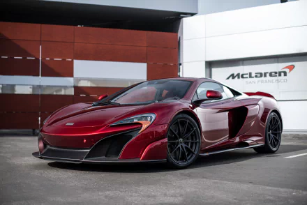 Sleek red McLaren 675LT supercar parked in front of a McLaren San Francisco dealership, captured in high-definition as a PC desktop wallpaper background.