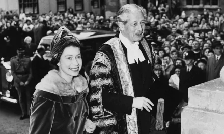 Black and white HD desktop wallpaper featuring a young Queen Elizabeth II smiling beside a formally dressed man at a public event with a crowd in the background.