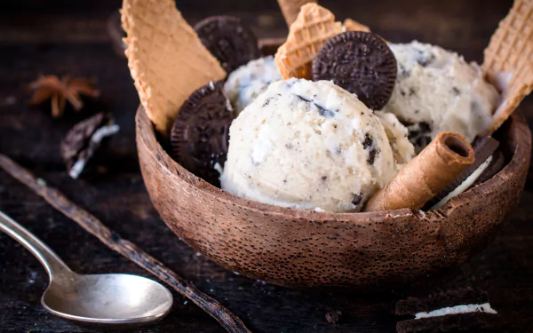 A 4K Ultra HD desktop wallpaper featuring a bowl of summer food: scoops of cookies and cream ice cream with waffle cones and cookie pieces.