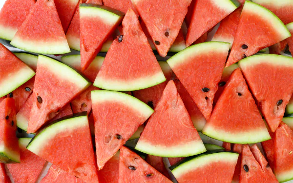 Close-up of triangular watermelon slices with red fruit and green rind, rendered in 4K Ultra HD as a vibrant PC desktop wallpaper and background.