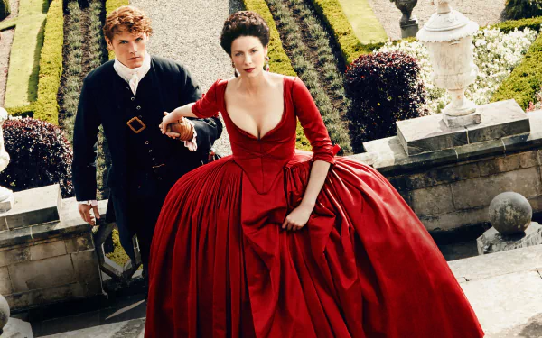 Claire Fraser and Jamie Fraser, portrayed by Caitriona Balfe and Sam Heughan, respectively, in a striking scene from the TV show Outlander, set against a beautifully manicured garden backdrop.
