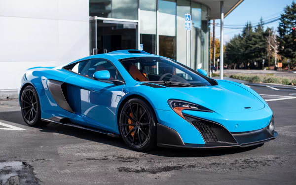 HD desktop wallpaper featuring a vibrant blue McLaren 675LT supercar parked outdoors in front of a modern building.