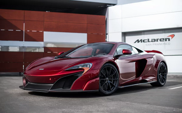 Sleek red McLaren 675LT supercar parked in front of a McLaren San Francisco dealership, captured in high-definition as a PC desktop wallpaper background.