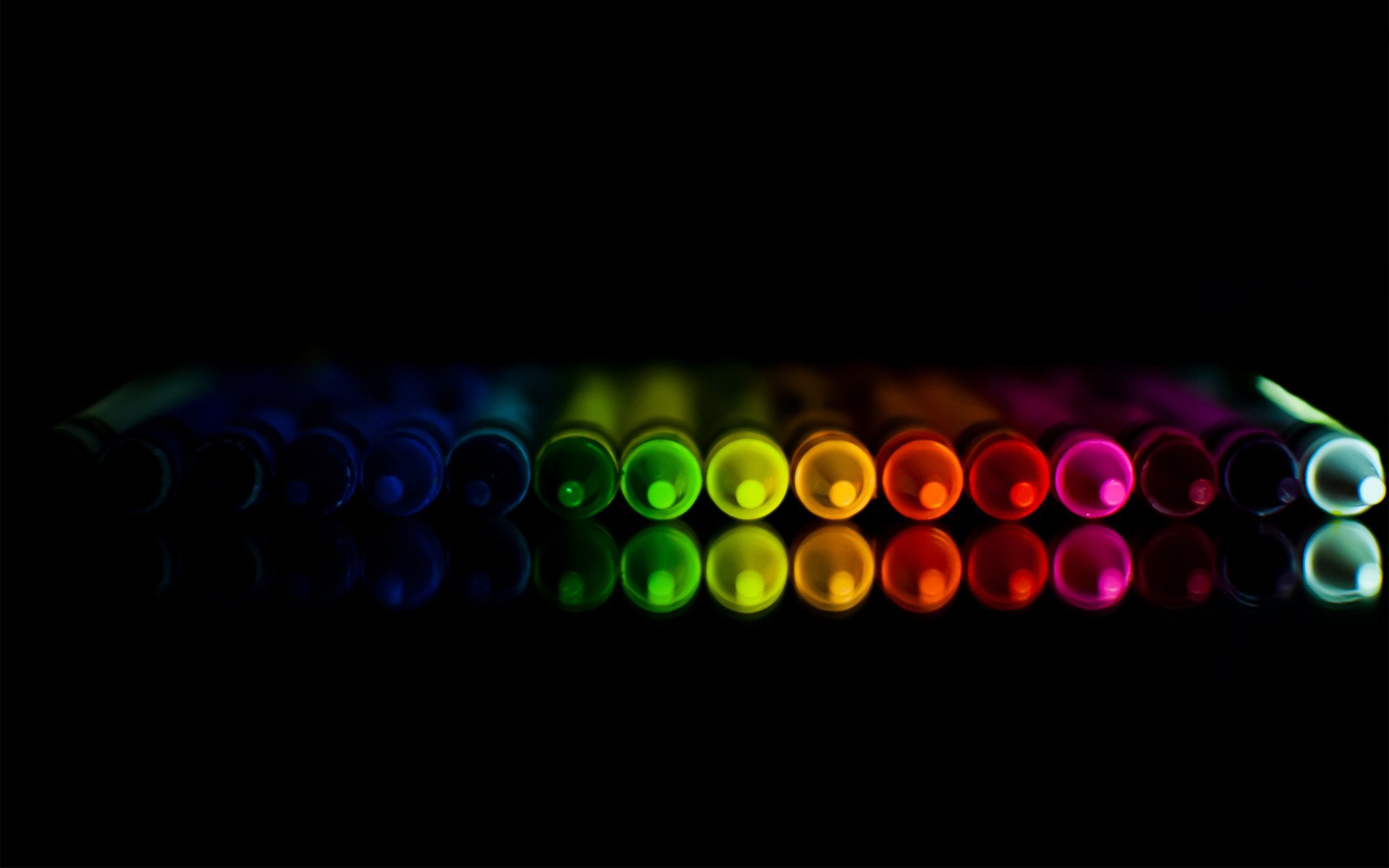 HD desktop wallpaper featuring a vibrant array of crayons with reflections against a black background, showcasing a spectrum of colors.