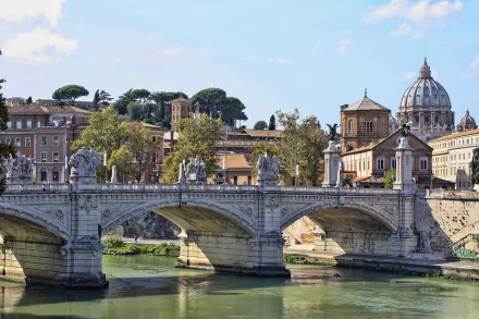 A stunning view of a historic bridge in Rome, Italy, showcasing intricate architecture against a serene river backdrop and the iconic dome of St. Peter’s Basilica in the distance.