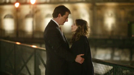 A romantic scene from *Sex and the City*, featuring a couple embracing on a dimly lit bridge, capturing the essence of love in a beautiful setting. HD wallpaper image.