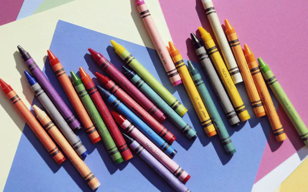 A vibrant array of crayons spread across a multicolored background, serving as an HD wallpaper showcasing creativity and color variety.