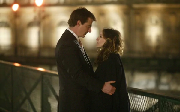 A romantic scene from *Sex and the City*, featuring a couple embracing on a dimly lit bridge, capturing the essence of love in a beautiful setting. HD wallpaper image.