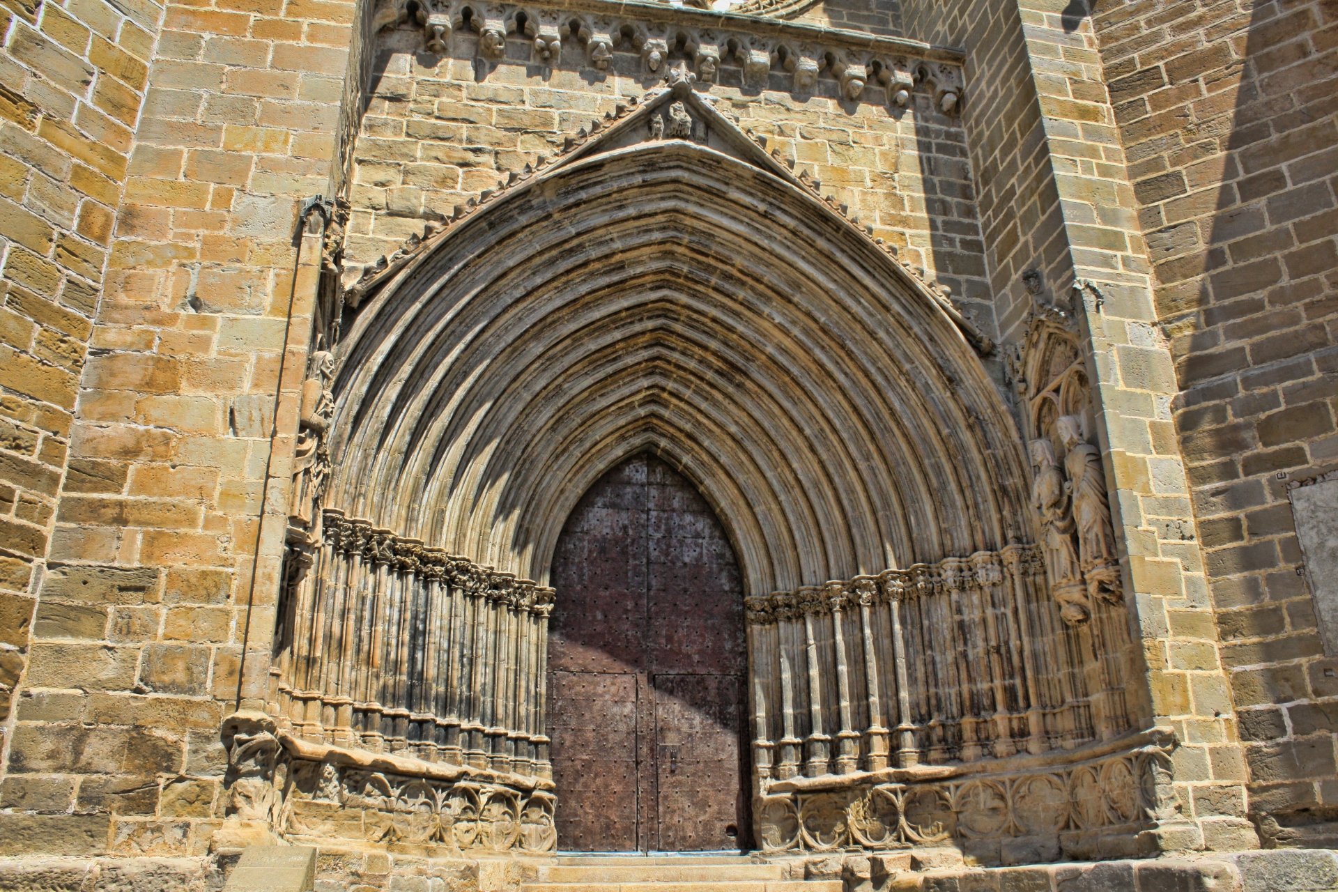 Detailed stone entrance of a historic religious church monument in Valderrobres, Spain, captured in striking 4K Ultra HD for a PC desktop background.