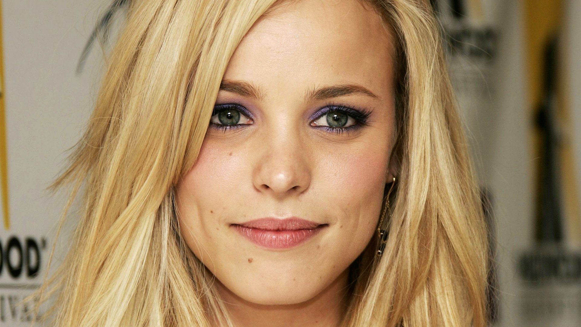 Close-up HD desktop wallpaper of celebrity Rachel McAdams with blonde hair and subtle makeup, looking directly at the camera.