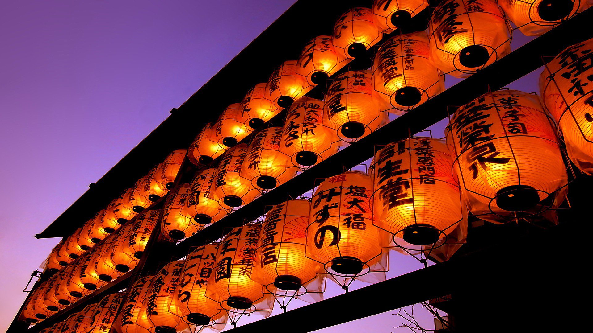 Rows of glowing orange man-made lanterns with Japanese characters hang against a deep purple sky, creating a striking HD PC desktop wallpaper background.