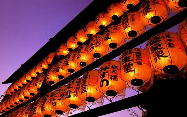 Rows of glowing orange man-made lanterns with Japanese characters hang against a deep purple sky, creating a striking HD PC desktop wallpaper background.