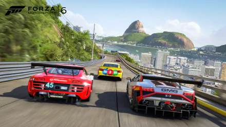 HD PC desktop wallpaper of the video game Forza Motorsport 6: three GT race cars sprint down a coastal city track with water, bridges and a rocky mountain in the distance.