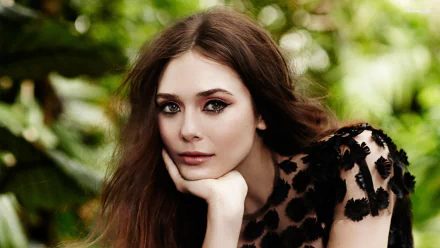 A stunning HD desktop wallpaper featuring celebrity Elizabeth Olsen, posing gracefully with a thoughtful expression amidst a lush green background.
