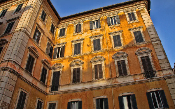 4K Ultra HD wallpaper showcasing a historic man-made building in Rome with warm yellow-orange walls under a clear blue sky.