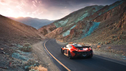 A stunning McLaren P1 supercar in vibrant orange, navigating a scenic winding road through mountainous terrain, with a breathtaking sunset illuminating the landscape.