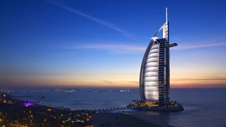 4K Ultra HD image of Burj Al Arab, the iconic man-made sail-shaped hotel in Dubai, illuminated against a twilight sky over the calm sea.