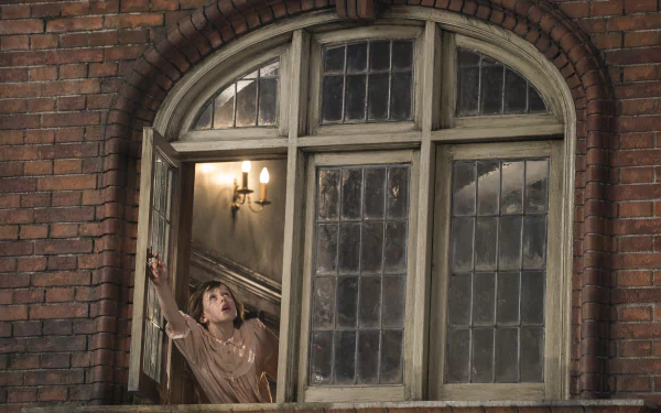 A scene from the movie The BFG (2016), featuring a young girl peering out of a large window in a brick building, creating a whimsical and enchanting atmosphere. HD desktop wallpaper.