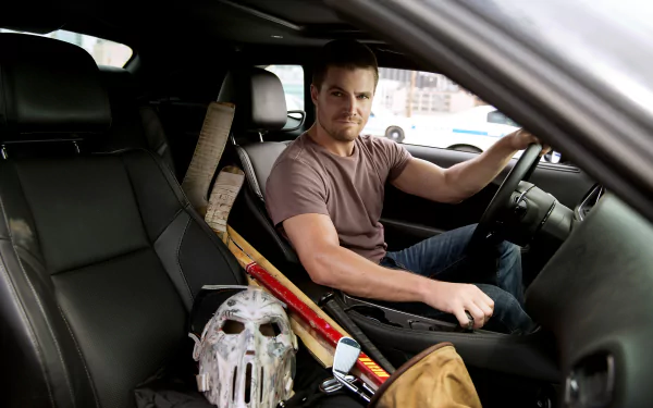 Casey Jones, portrayed by Stephen Amell, sits in a car with sports equipment and a hockey mask, capturing a moment from Teenage Mutant Ninja Turtles: Out Of The Shadows. HD desktop wallpaper.