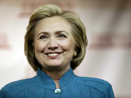HD desktop wallpaper featuring a portrait of a smiling Hillary Rodham Clinton against a blurred background.