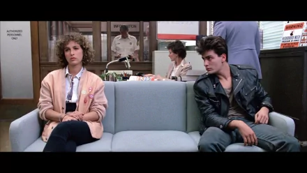 A scene from Ferris Bueller's Day Off, featuring two characters sitting on a couch in a waiting area, capturing the film's quirky vibe in this HD desktop wallpaper.