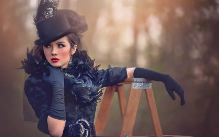 A brunette woman model with brown eyes wears a black dress, black gloves, bold lipstick, and a stylish hat, posing outdoors against a blurred natural background.