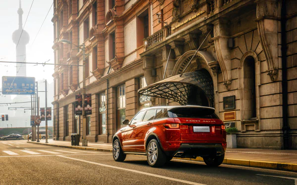 A Range Rover Evoque parked on a city street, showcasing its sleek design against an urban backdrop with historic architecture and a modern skyline in the distance. 4K Ultra HD quality.