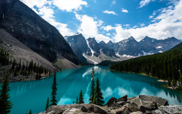A stunning view of Moraine Lake, featuring vibrant turquoise water surrounded by towering mountains and lush evergreen trees, captured in rich detail for a breathtaking nature wallpaper.